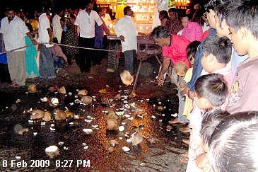 Devotees smash coconut as an act of fulfilling vows